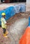 Construction workers mixing and spraying the anti termite chemical treatment to the soil at the construction site.