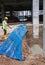 Construction workers mixing and spraying the anti termite chemical treatment to the soil at the construction site.