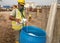 Construction workers mixing and spraying the anti termite chemical treatment to the soil at the construction site.