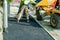 Construction workers placing hot tarmac during roadworks