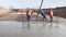 Construction workers pour concrete base on building ground