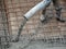 Construction workers pour wet concrete using a hose from the elephant crane or concrete pump crane at the construction site.