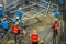 Construction workers are pouring concrete in post-tension flooring work. Mason workers carrying hose from concrete pump or also kn