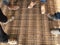 Construction workers wearing steel toe safety shoes standing on top of the steel reinforcement bar.