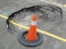 Constructions at unexpected sink hole in public parking lot with traffic cone