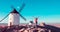 Consuegra Windmills and happy woman arms raised admiring panoramic view- Spain