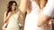 The consultant helps the young woman try a wedding dress. Girl happy to selected wedding dress. young bride makes selfie