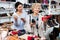 Consultant in shoeshop helping old woman to choose footwear