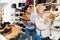 Consultant in shoeshop helping old woman to choose footwear