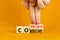 Consume or communicate symbol. Concept word Consume or Communicate on wooden cubes. Beautiful orange table orange background.