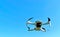 Consumer drone with camera hovering against sky