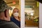 A consumer interacts with mask-wearing pharmacy tech at local CVS Pharmacy drive-up window editorial