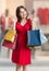 Consumerism concept. Young shopaholic woman is shopping with colorful bags