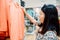 Consumerism Woman is Happiness While Shopping Clothes in Department Store, Portrait of Young Woman Choosing Clothes on a Rack in