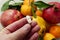 Consuming natural fruit instead of vitamin pills, comparison with vitamin pills and natural fruits in a person`s hand, close-up