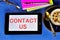 Contact us-business interactions. A written message on a tablet PC. To communicate, you need the phone number or email address of