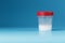 A container for biomaterials with sperm analysis and a red lid on a blue background