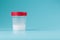 A container for biomaterials with sperm analysis and a red lid on a blue background