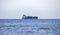 Container cargo ship loaded in blue calm sea background