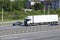 Container chassis truck driving on highway near cars