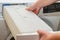 A container for condensate from the dryer, a woman takes out a tank with accumulated water after drying clothes from the