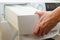 A container for condensate from the dryer, a woman takes out a tank with accumulated water after drying clothes from the