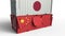 Container with flag of Japan breaks cargo container with flag of China. Trade war or economic conflict related