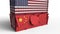 Container with flag of the USA breaks cargo container with flag of China. Trade war or economic conflict related