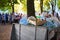 The container is full of garbage. Residents of the city celebrating a holiday in the background