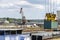 A container gantry crane on a rail loads the container into a barge standing on the banks of the river Rhine in Germany.