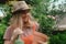 Container gardening. Woman gardener watering potted roses using spray bottle.