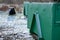 Container of green color for garden waste. it is weighed for bio composting or for thermal use as wood chips. The street and lawn