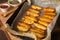 Container with homemade baked potato wedges with spices on parchment paper