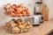 Container with potatoes and onions on wooden kitchen counter. Orderly storage