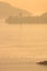 Container ship crosses the sea in the Gulf of La Spezia in front of Portovenere. Warm light of the setting sun.