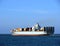 Container Ship with Full Load Sailing Away at Sea