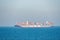 Container ship `HMM Algeciras` sailing through calm blue ocean.