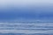 A container ship navigates through the Juan De Fuca Strait on a gloomy and calm morning