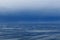 A container ship navigates through the Juan De Fuca Strait on a gloomy and calm morning