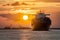Container ship sails at sunset, representing international freight shipping