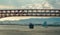 Container ship sails under bridge in harsh late-afternoon sun