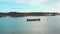 Container ship and small boat in calm sea