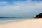 Container shipping by the sea. Sand beach tropical summer background. Cargo ship.