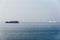 Container ships passing an offshore windpark in morning mist