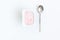 Container with strawberry yogurt and spoon, top view, isolated o