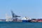 A container terminal in Jersey City, NJ with gantry cranes and a roll on, roll off RoRo ship, unloading vehicles