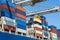 Containers being discharged from a large container ship by a crane in the port of Rotterdam, Europe