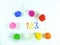 Containers with colorful plasticine and the child made numbers one , two, three.  white  wooden background.