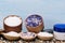 Containers with different floral sea salt, next to spoons, on small stones and cream