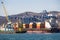 Containers on freight ship in industrial sea port for shipping and logistic, cranes and other special equipment